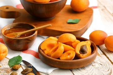 Tasty ripe apricots with jam on table