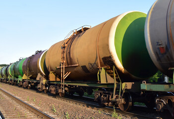 Fototapeta na wymiar Transport tank car LNG by rail, gas - oil products. LPG transport propane. The fuel train, rolling stock with petrochemical tank cars. Liquefied natural gas export. Object in Motion, Out of focus