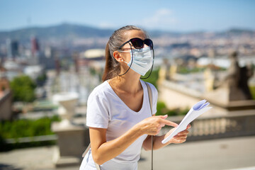 Young woman wearing disposable face mask for stop spreading of virus disease walking near museum, observing sightseeings, new normal due to coronavirus outbreak..