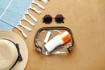 Fototapeta na wymiar Bag with cosmetics, sunglasses and hat on color background