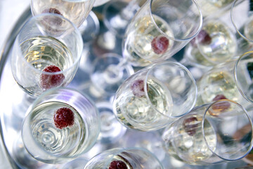 Serving tray with glasses of champagne with raspberries on top at the event. Top view. View from top.