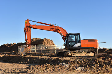 Excavator Working On Road Construction in City. Backhoe on Earthworks. Heavy Construction Equipment...
