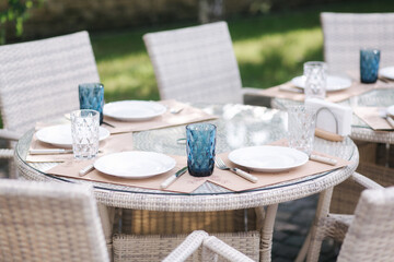 Served table set at summer terrace. Cutlery in cafe. Green background