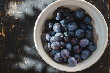 Bowl of fresh blueberry on kitchen table close up