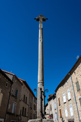 Fototapeta premium Stone cross and Flowers ,in the medieval town of Malzieu , lozere France .a stage in the way of compostelle a long distance walk .