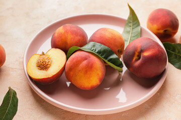 Fototapeta na wymiar Plate with ripe peaches on color background