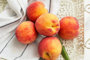Naklejka na ściany i meble Tray with ripe peaches on table, closeup