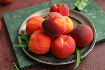 Tray with ripe peaches on table