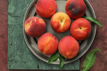 Tray with ripe peaches on table