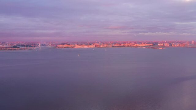 Saint-Petersburg City Skyline and Gulf of Finland at Summer Sunset. Stadium and Cable-Stayed Bridge. Aerial View. Russia. Drone Flies Sideways, Tilt Up