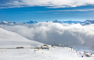 Fototapeta na wymiar Landscape of ski slopes and Swiss alps, covered with clouds, in winter resort Davos, Switzerland.