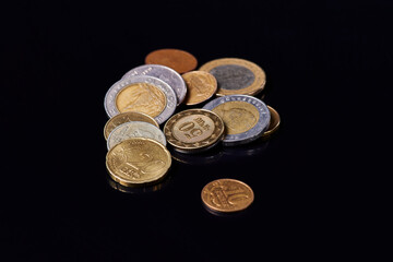coins of different countries, on black glass