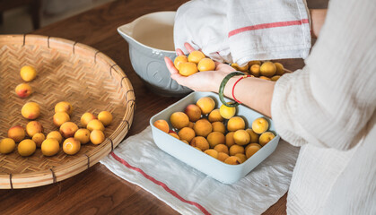 一双手正在用毛巾擦拭成熟的梅子