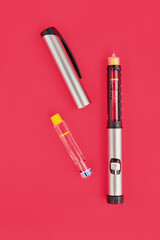 Insulin Pen on pink background, close-up, flat lay. Diabetes control concept