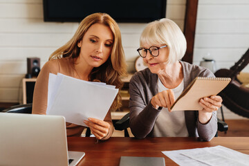 Caucasian woman explaining some documentation or bill papers to parent at home