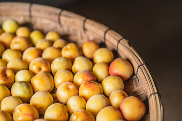 plenty of fresh plums in bamboo basket