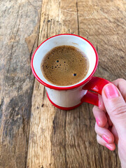 closeup hand of woman holding a cup of coffee.