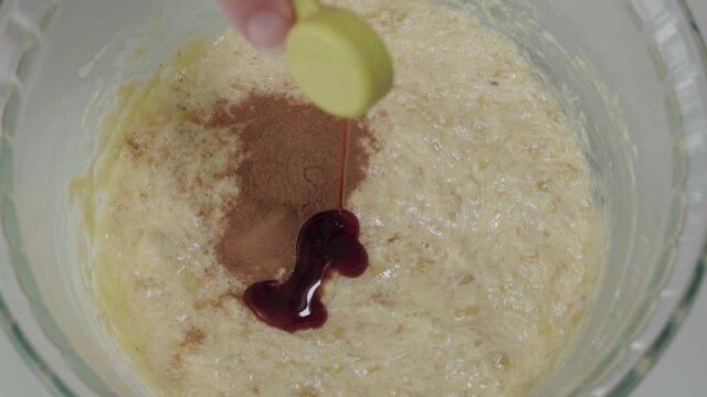 Pouring Teaspoon Of Vanilla Extract Into Yellow Batter, Slowmo Overhead Closeup