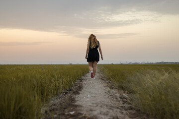 Mujer caminado por un arrozal en Valencia