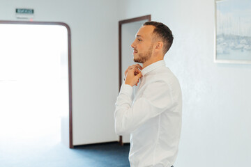 Fototapeta premium Portraits of the groom at the hotel training camp, dressed as a businessman in a black suit, tuxedo and white shirt