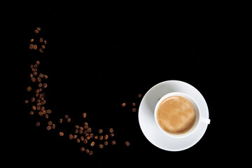 coffee cup with coffee beans on a black background from above