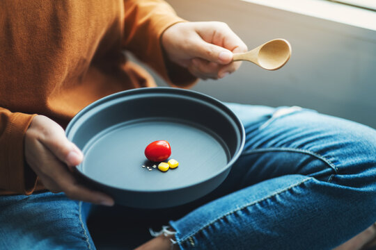 Closeup Image Of A Woman Holding And Eating Small Amount Of Food For Diet Concept