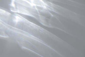 Blurred water texture overlay effect for photo and mockups. Organic drop diagonal shadow and light caustic effect on a white wall. Shadows for natural light effects