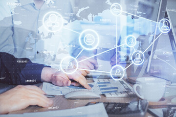 Social network theme hologram with businessman working on computer on background. Multi exposure.