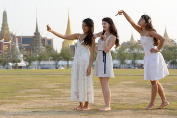 Obraz premium Three multi ethnic young beautiful women as friends together in the park