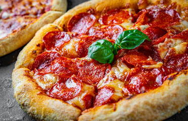 Pepperoni Pizza with Mozzarella cheese, salami, Tomato sauce, pepper, Spices. Italian pizza on Dark grey black slate background