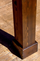 Detail shot of a wooden garden house leg standing on the floor tiles.