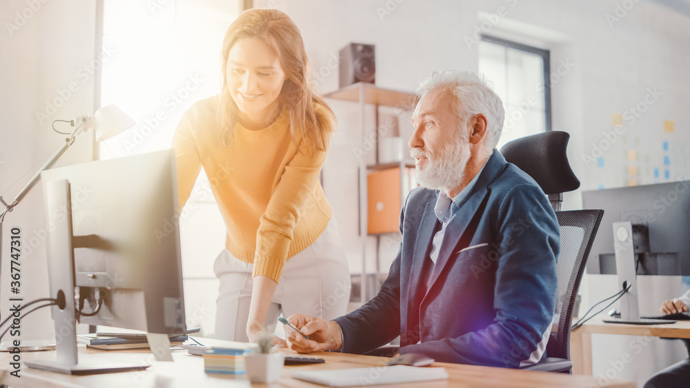 Poster handsome middle aged creative engineer sitting at the desk working on desktop computer has discussio