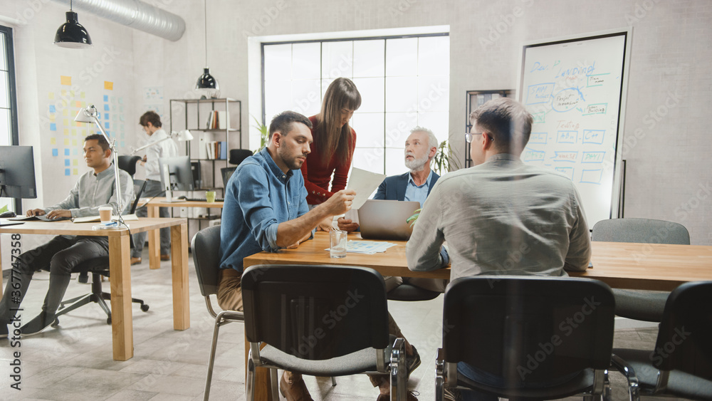Aufkleber in the stylish modern office: diverse group of enthusiastic business marketing professionals use com