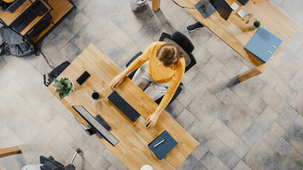 Top View Shot of a Beautiful Young Female Specialist Sitting at Her Desk Working on Desktop...