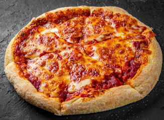 sliced Pizza with Mozzarella cheese, Tomatoes, pepper, Spices. Italian pizza. Pizza Margherita or Margarita on Dark grey black slate background