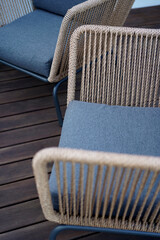 Close up details shots of arm chairs standing on a wooden terrace deck   