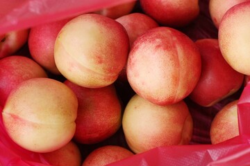 Ripe juicy nectarines in a red bag