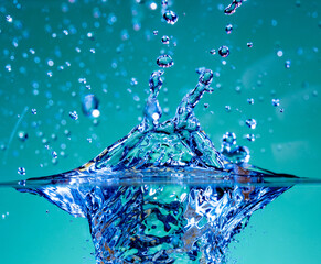 Water splash and air bubbles rise in clear water.