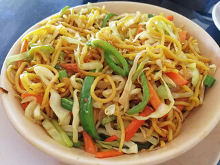 a bowl of noodles with vegetables close-up served in a cafe. delicious dish of Asian cuisine