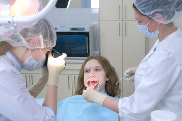 Dentist orthodontist photographing using camera girl teeth showing it in mirror. Orthodontic checkup in dentistry. Preventive examination. Preparing to cure in stomatology clinic.