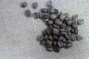 Roasted coffee beans on the sackcloth background