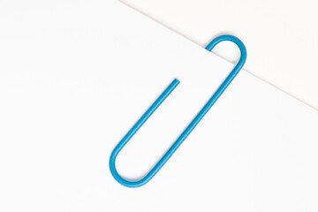 Blue paper clip on white paper
