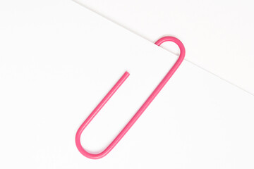 Pink paper clip on white paper
