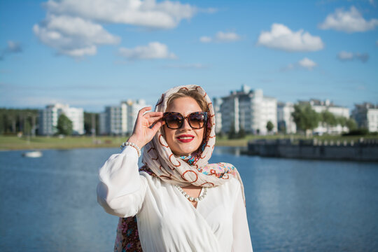 elegant portrait of young woman in headscarf and long white dress