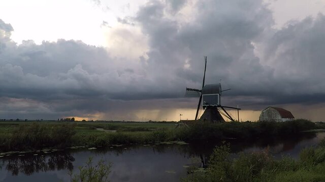 Time lapse of the motion of upcoming storm clouds over a windmill in a classic dutch polder landscape