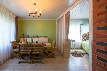 Living room in studio apartment with furniture. Table, chairs and sofa. Private house.