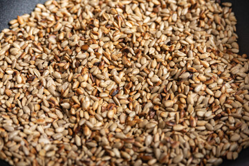 Fried sunflower seeds in a frying pan, peeled.