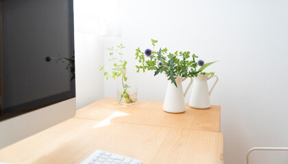 明るい窓　木製デスク　観葉植物とパソコン　オフィス　リモート　オンライン　テレワーク　背景　余白　コピースペース　白背景　シンプルナチュラル