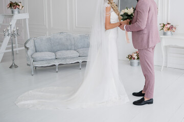 Obraz na płótnie Canvas groom with bride in studio and bouquet