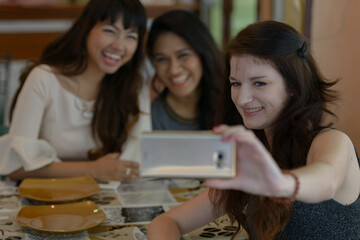 Three young beautiful women as friends together at the coffee shop
